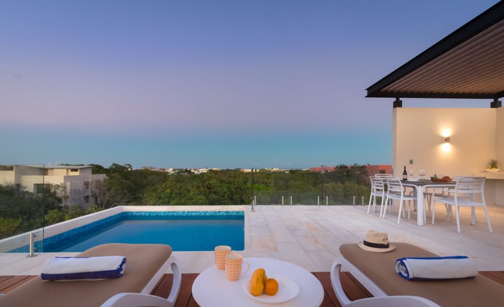 Rooftop plunge pool and covered dining at dusk