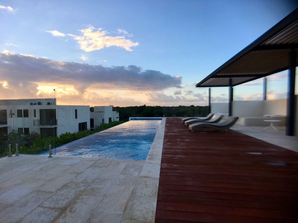 Rooftop infinity pool at dusk with loungers