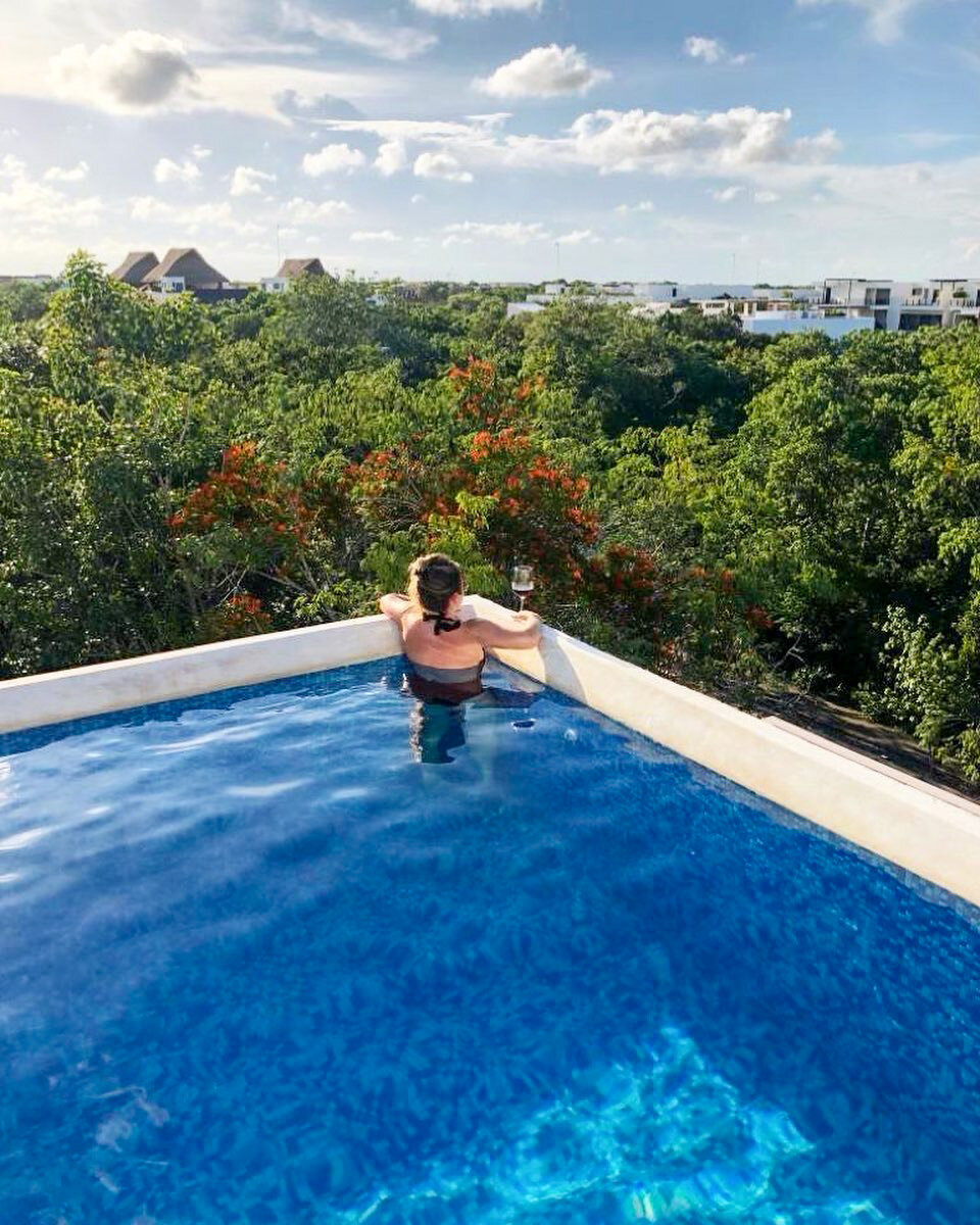 Guest in the private rooftop plunge pool above the jungle canopy at Imagine Tulum Penthouse, The Highline Tulum